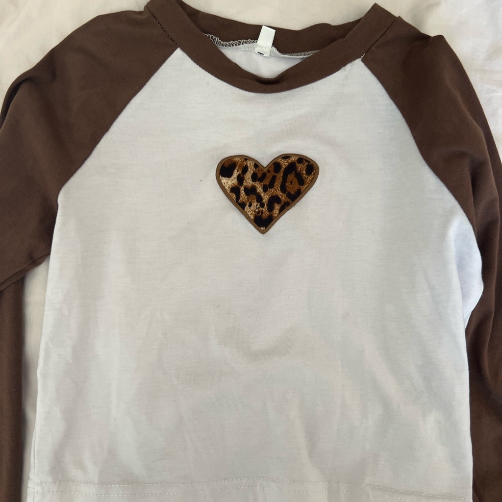 A White Top With Brown Sleeves And A Cheetah Print Heart.